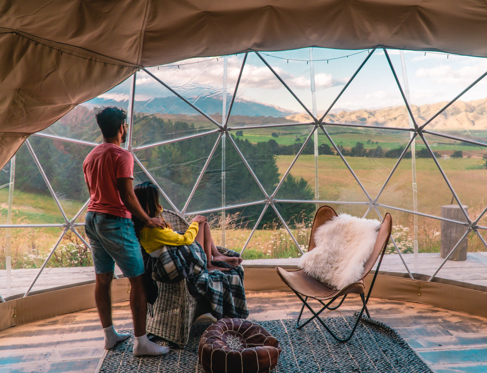 couple looking out dome windows at asheville glamping