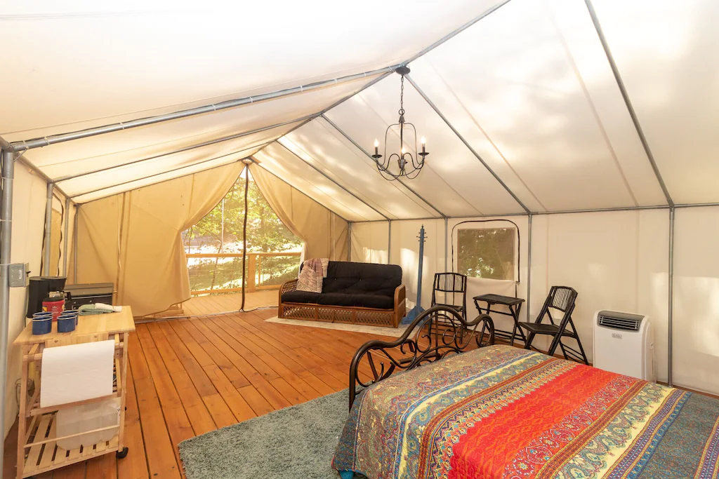lux tent with bed and couch and table and chairs, a great site for glamping in tennessee