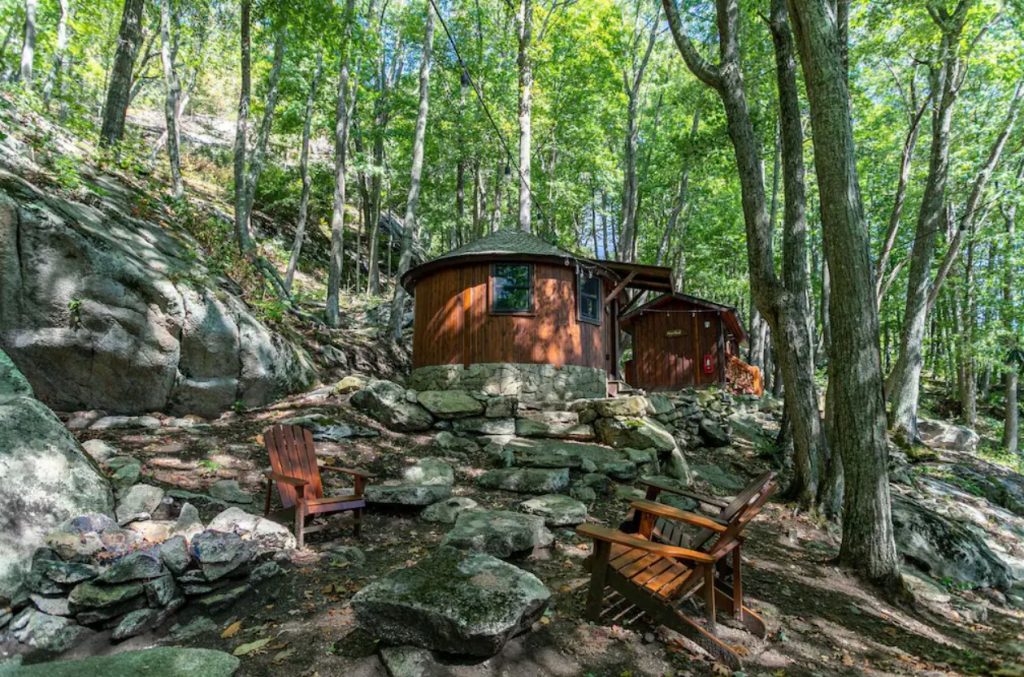 A cedar yurt on top of a rocky hillside surrounded by trees in NC. It's a great spot for glamping in North Carolina. 