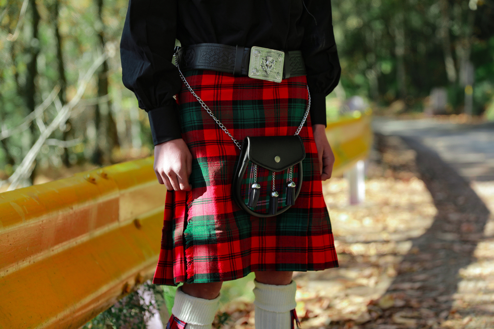 Man standing wearing red and green kilt