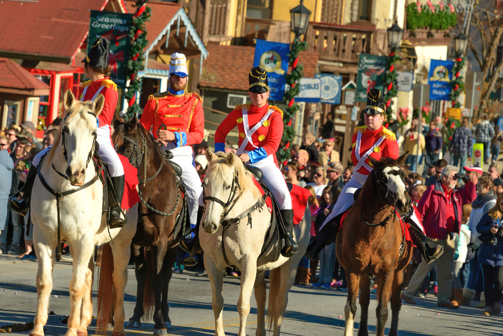 people dressed as nut crackers ride horses in the streets during christmas in helen