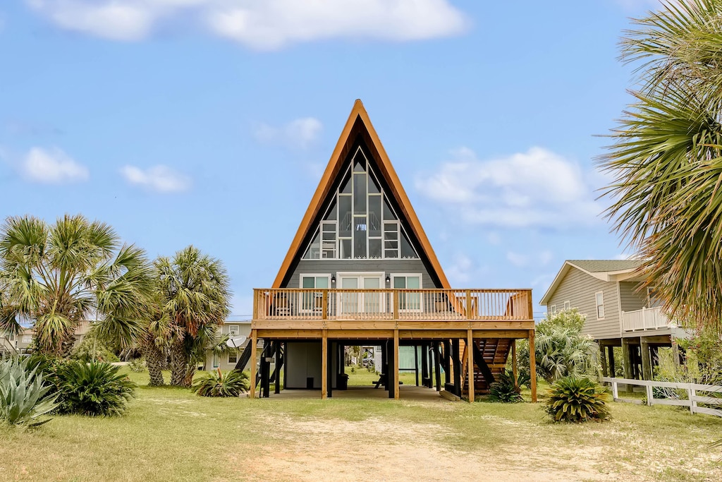 the palm trees and blue sky surrounding the unique beachside aframe, one of the best airbnbs in Alabama 