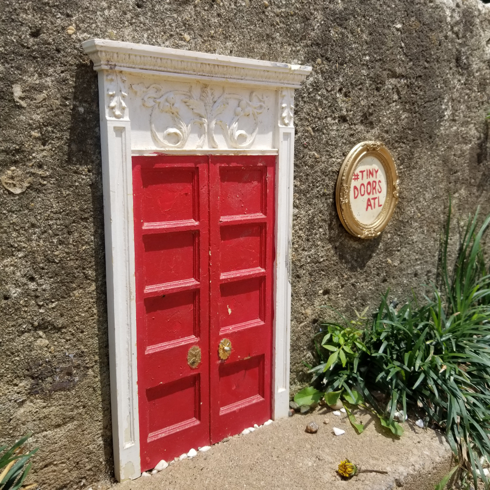 The Tiny Doors in Atlanta are literal tiny door sculptures: this red one sits on the side of a building and hunting for them is one of those fun yet free things to do in Atlanta. 