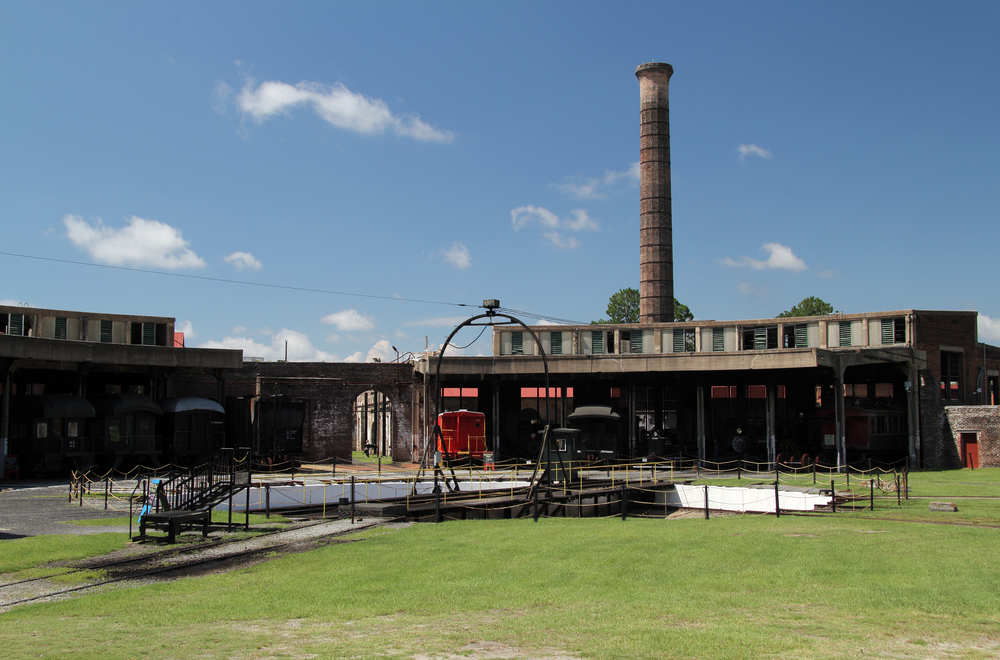 The exterior of the Georgia State Railroad museum in Savannah. There are old terminal buildings, and an area where you can ride a train. 