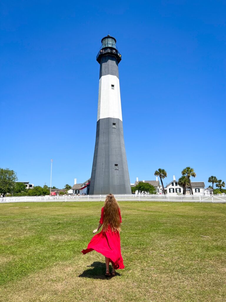 woman standing in front of the tybee island lighthouse in georgia