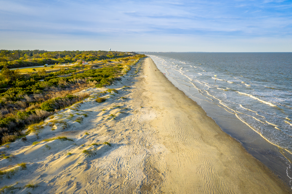 Sandy shore of a long stretch of beach of Jekyll Island, one of the best beach towns in Georgia.