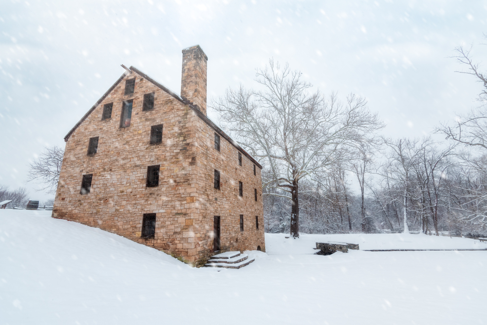 An old brick building at Mount Vernon in the snow while it is snowing. 
