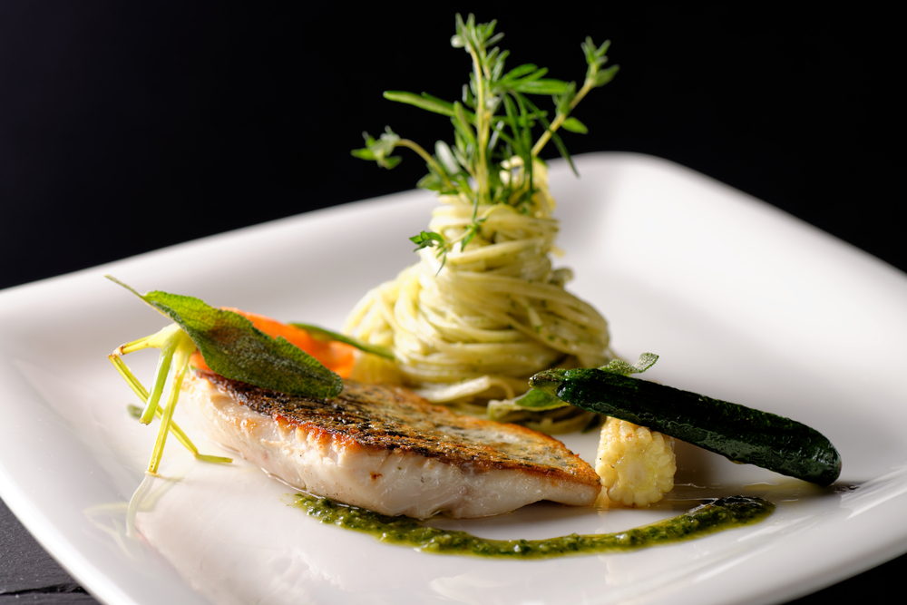 an upscale fine dining meal of fish with homemade pasta and grilled zucchini