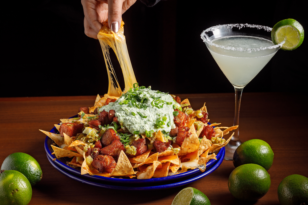 Nachos, a margarita and limes.