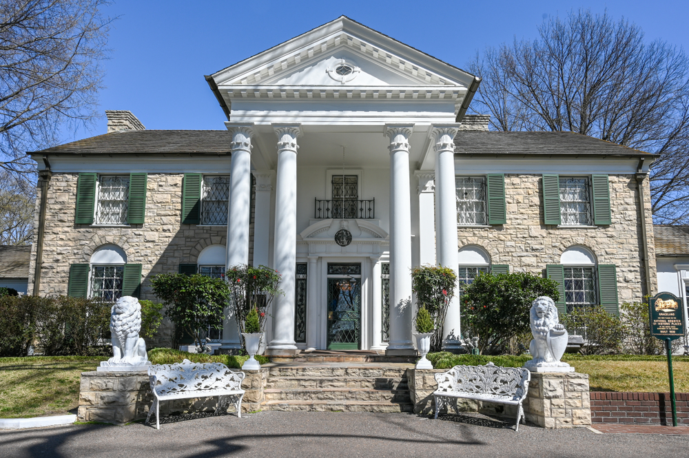 Elvis Presley's Memphis home, Graceland, a white stone mansion with four white columns and two stone white lions. Add Graceland to your list of things to do on your romantic getaway in Tennessee!