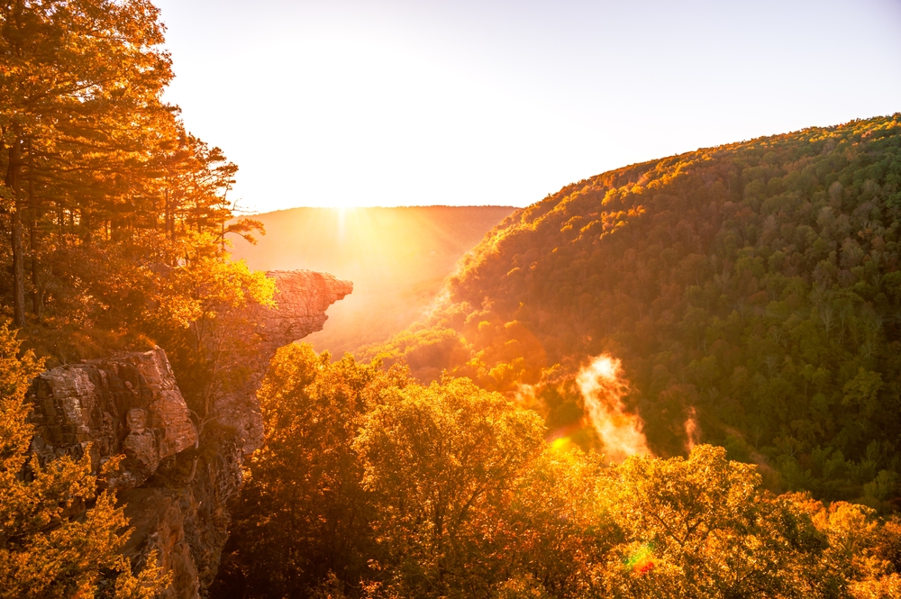 Sunrise at a high point during the fall with golden leaves. Chasing fall foilage is one of the romatic getaways in Arkansas 
