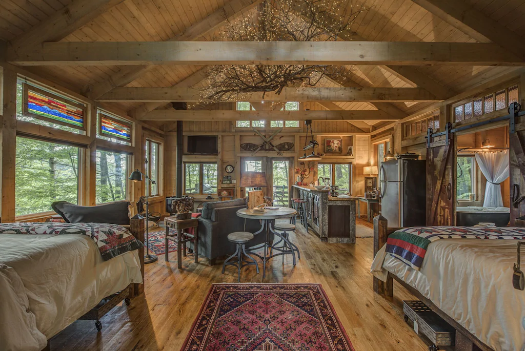 inside of amazing cabin with two beds, living room, and kitchen
