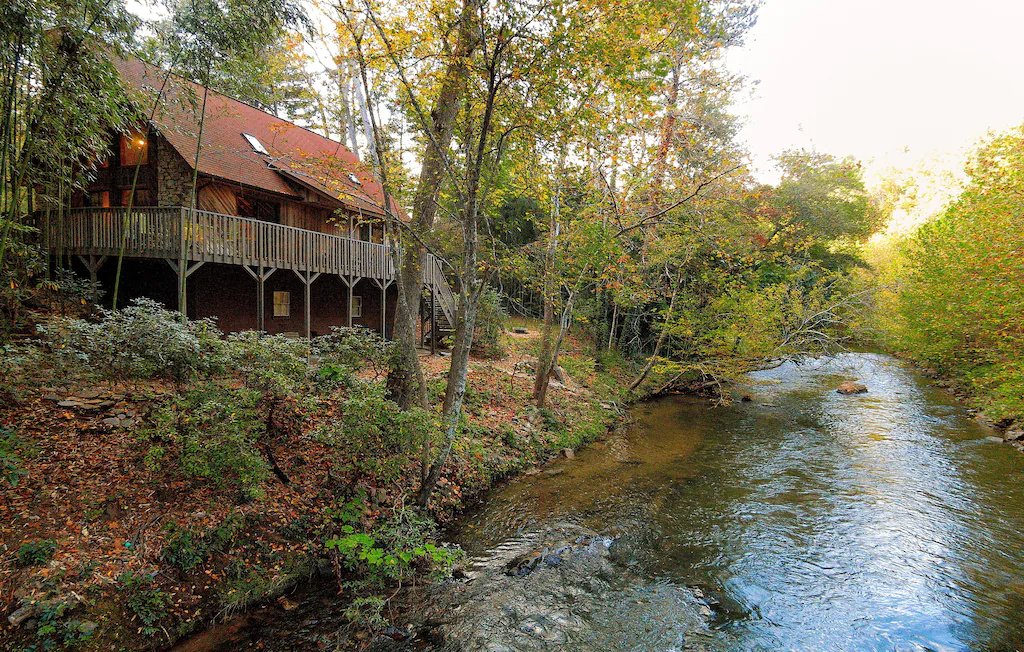 river running in front of cabin in woods