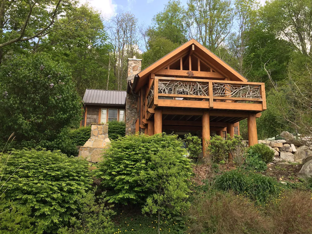 looking up at cabin on mountain with large deck