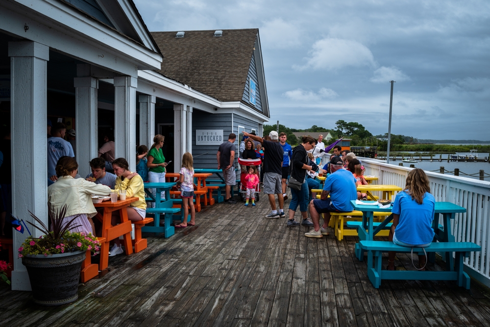 landscape photo of people having lunch on the boardwalk waterfront in Duck