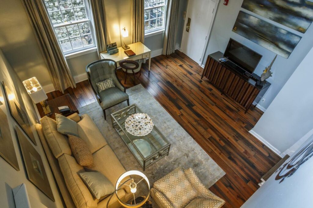 A view from above, looking down on the sitting area of a two-story suite within the Olde Harbour Inn, one of the best boutique hotels in Savannah.