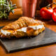 Brie and apricot preserve croissant on a slate serving plate