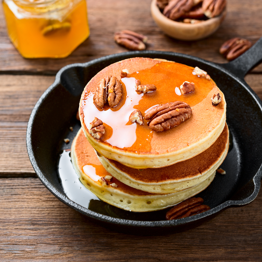 Three thick pancakes topped with honey and pecans, the pancakes at Southern Pancake House make it one of the best places for breakfast in Williamsburg Virginia. 