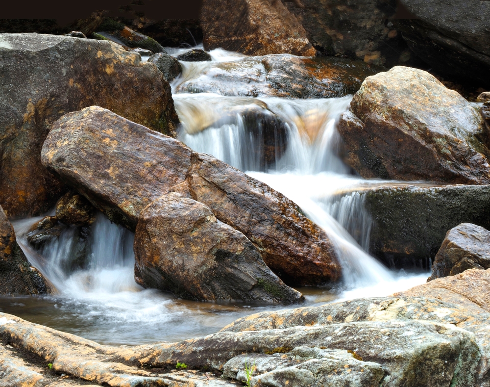 Close up section of Skinny Dip Fall flowing among rocks.