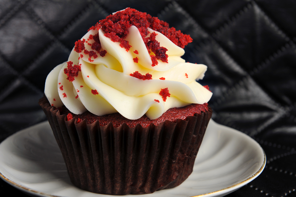 Close up of a red velvet cupcake with oodles of icing.