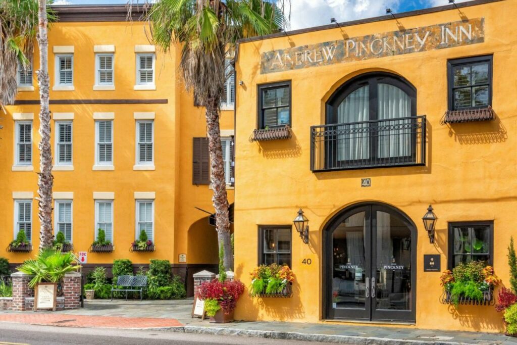 A bright yellow building with old iron window balcony castings featured on one of the best boutique hotels in Charleston