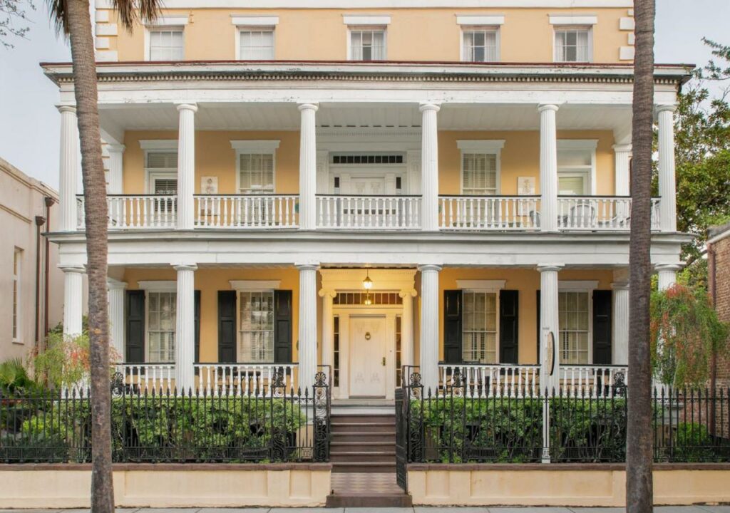 a pleasant yellow building with wrap around balconies featured on one of the best boutique hotels in Charleston, SC