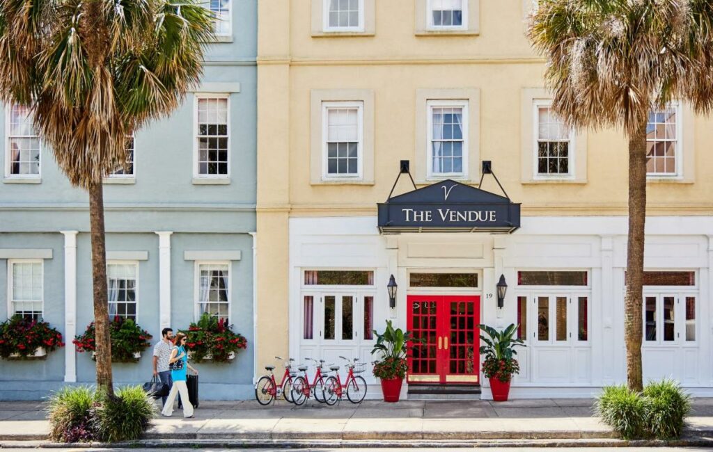 A cheery yellow building with a red door, an exterior view of one of the best boutique hotels in Charleston