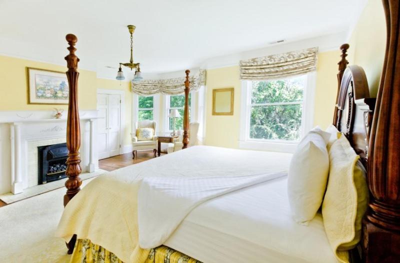 bright yellow room with open windows and a fireplace, featured at one of the best boutique hotels in Asheville.