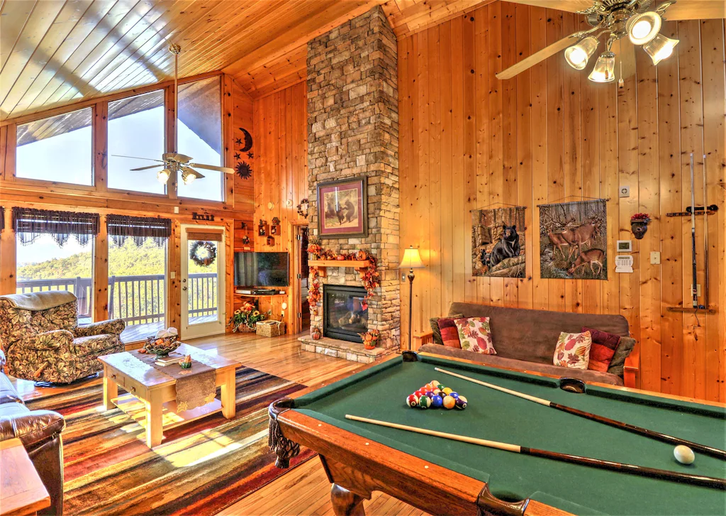 an indoor view of great wood panels and a pool table of a listing on our list of the best cabins in the smoky mountains