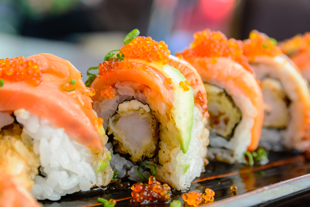 up close photo of sushi with shrimp inside and roe on top