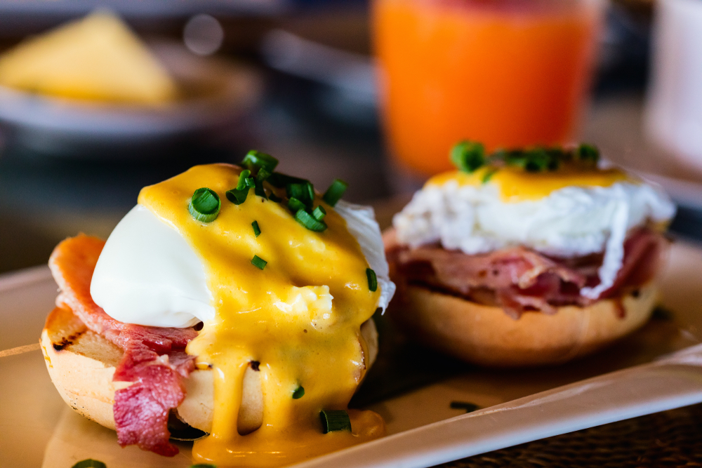 eggs benedict on a plate with a drink in the background. another broken egge cafe, one of the best restaurants in columbia sc