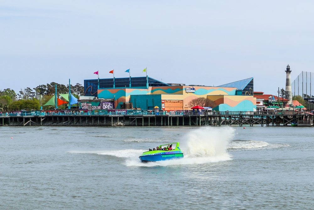 A jet boat ride carries passengers for a thrill ride at Broadway at the Beach entertainment complex, with the Ripley's Aquarium in the background.