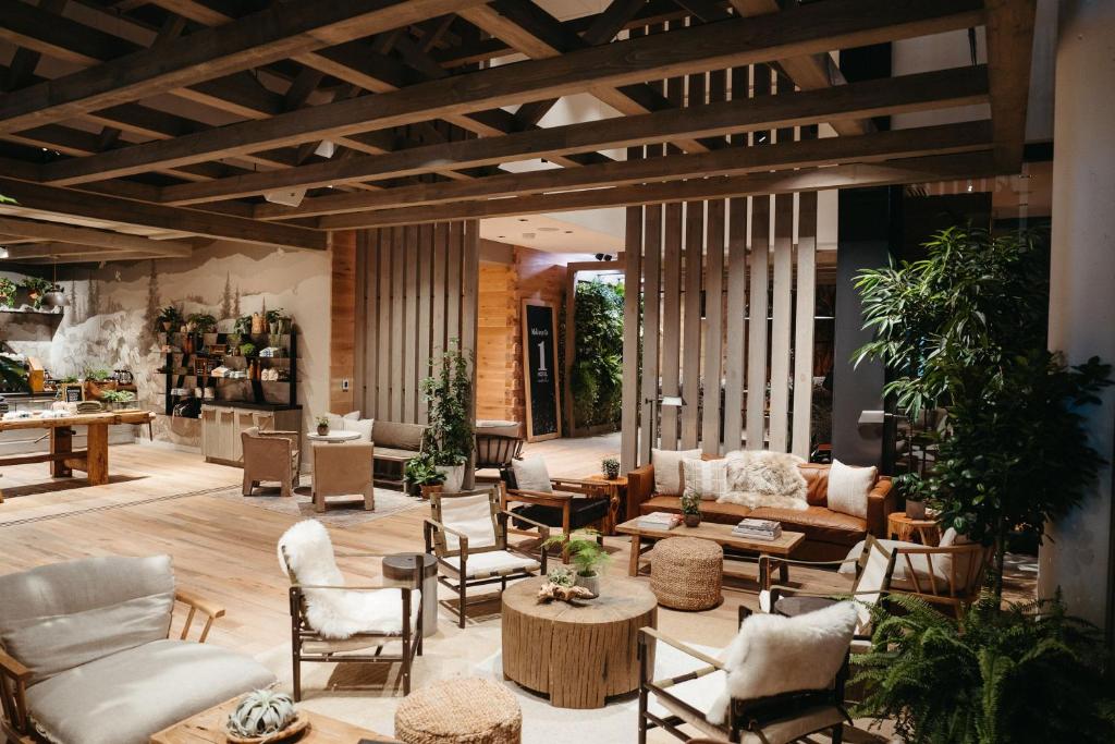 A lovley hotel lobby with lots of wood and cream and brown chairs. There are lots of plants. It is one of the best boutique hotels in Nashville.