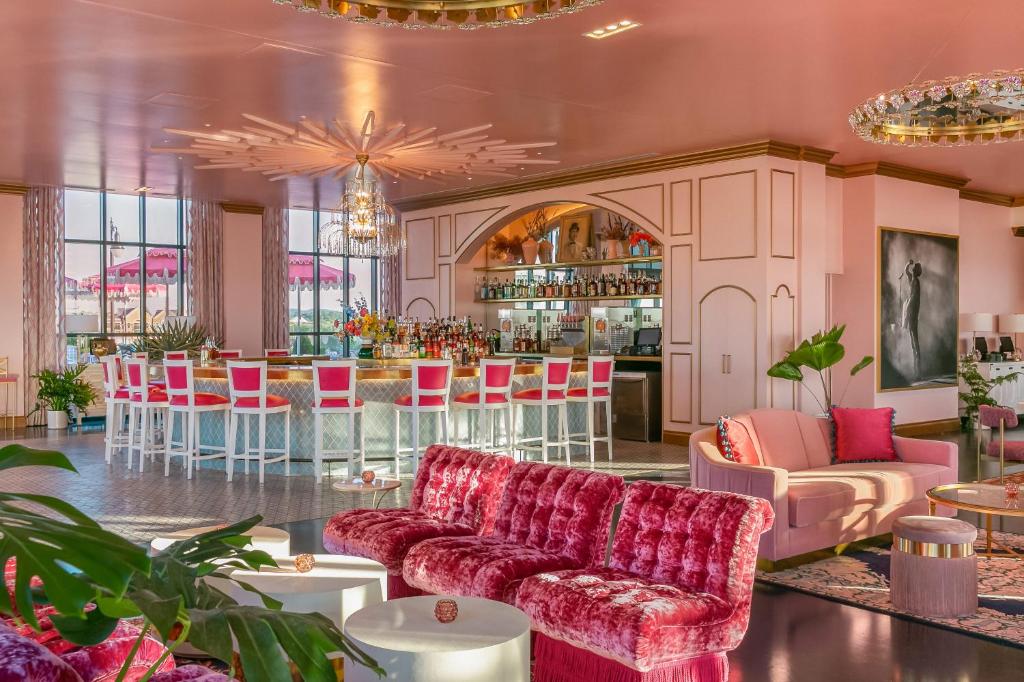 The pink lobby of The Graduate with pink chairs and a pink bar. It is one of the best boutique hotels in Nashville.