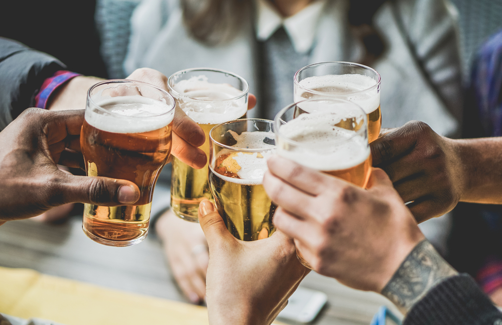 Photo of friends cheersing beers at Parkway Brewing Company, one of the best breweries in Roanoke. 