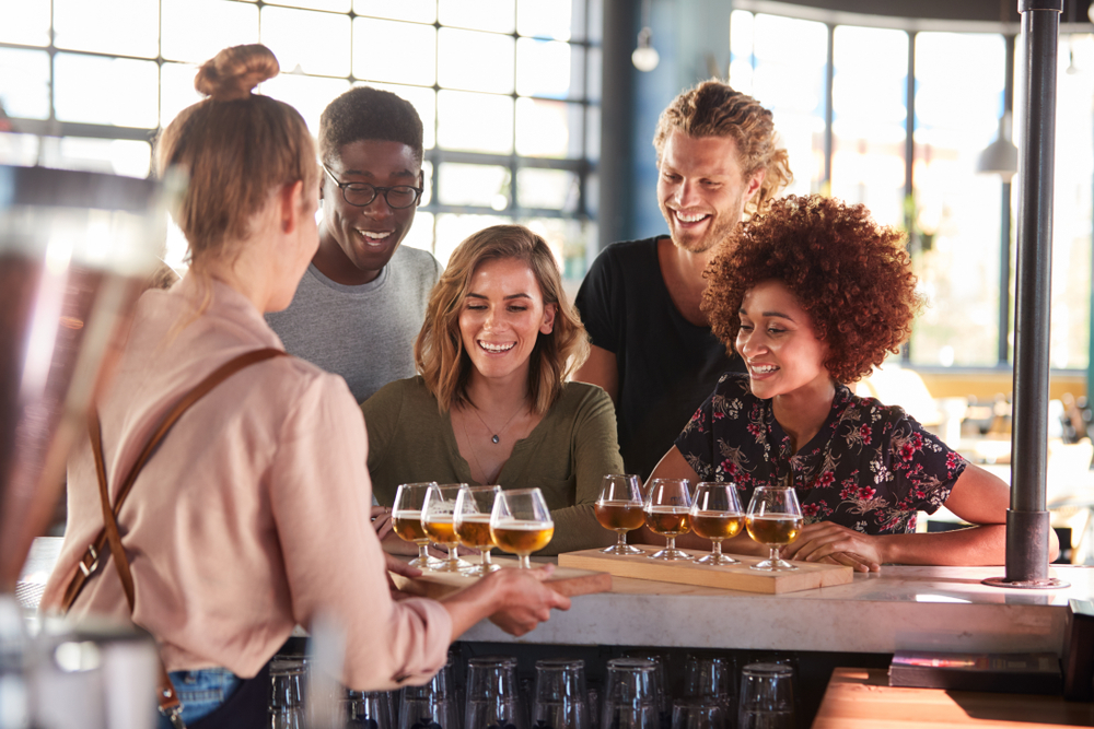 Photo of friends enjoying a flight of beer at Twin Creeks Brewing Co. 