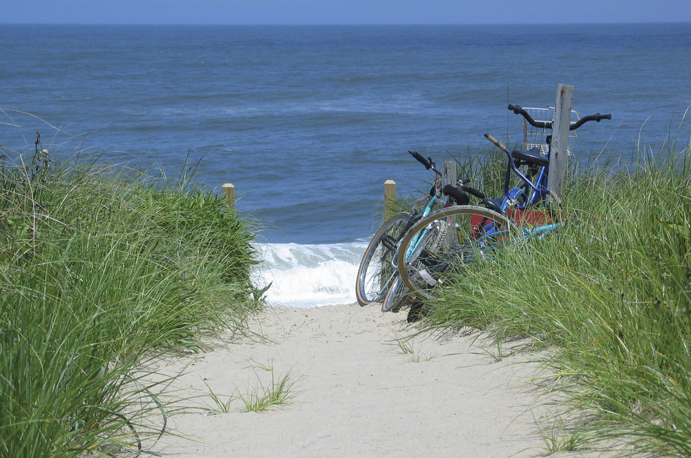 bikes parked on waters edge in the sand