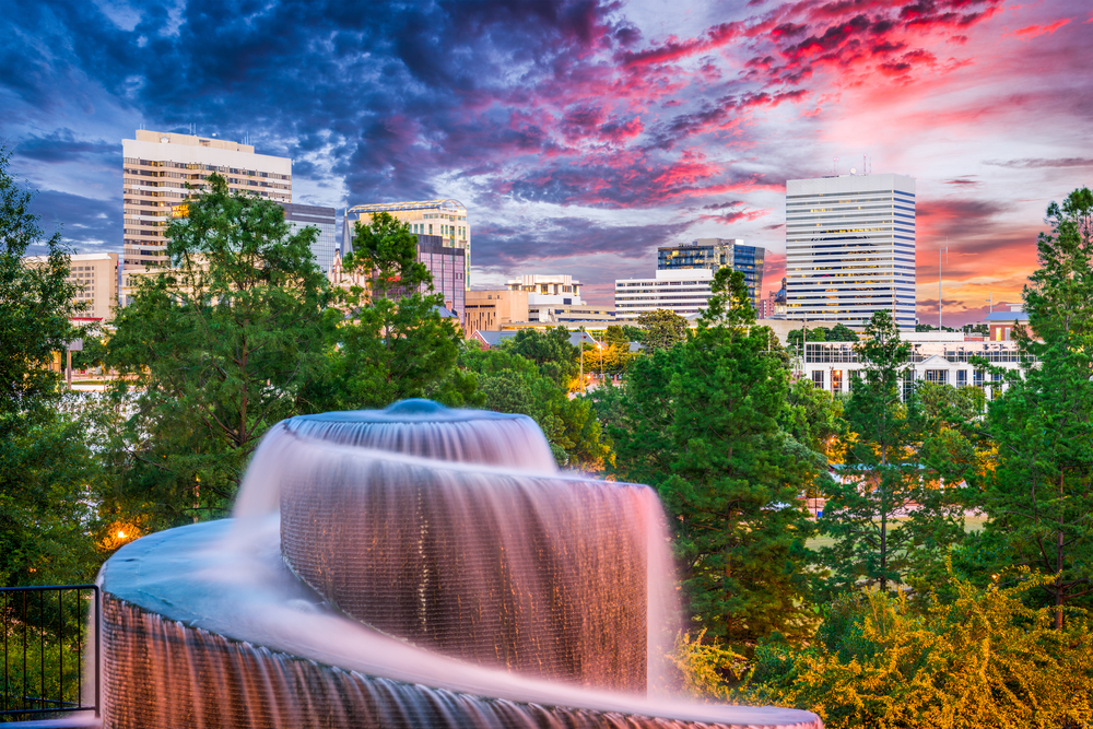 Visiting Columbia is one of the weekend getaways in South Carolina . This picture shows the city skyline in the background and a waterfall in the front. 