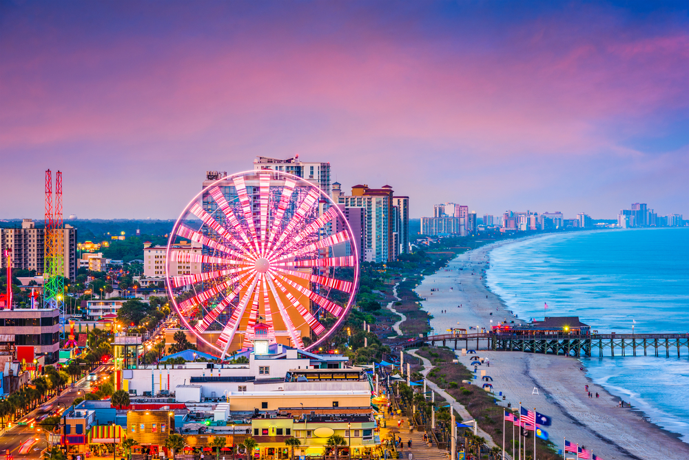 Myrtle Beach skyline. It shows the beach and the attractions near the beach including a large ferris wheel. 
