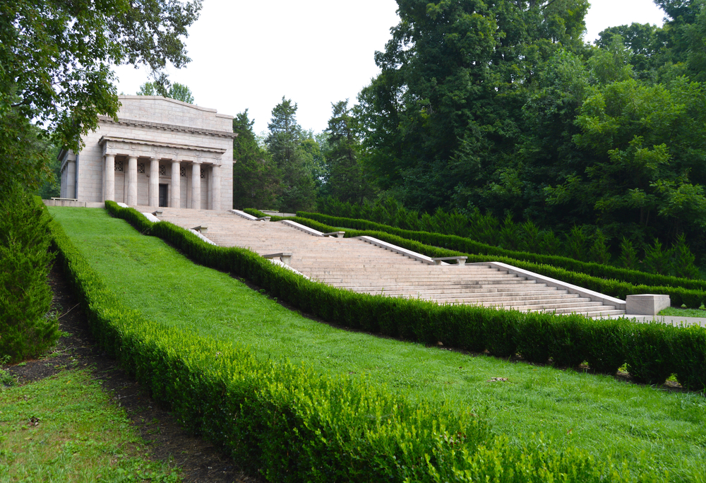 The First Lincoln Memorial sitting at the top of many stairs surrounded by greenery.