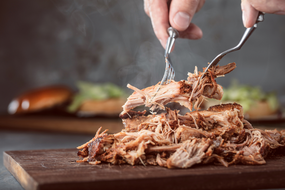 slow cooked North Carolina Barbecue being pulled apart with two forks 