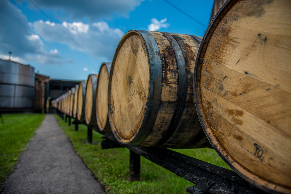  Bourbon barrels at a distillery along the Bourbon Trail in Kentucky. The article is about the Best Bourbon Distilleries In Kentucky