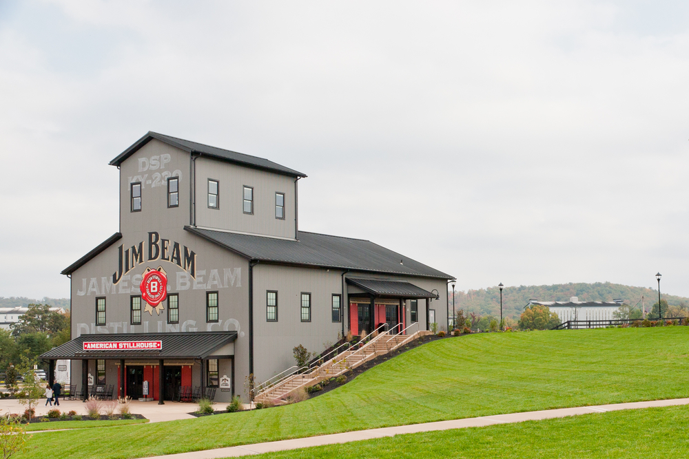  Jim Beam Distillery at Clermont, KY. The picture shows the grey Jim Beam building and rolling hills. One of the Best Bourbon Distilleries In Kentucky 