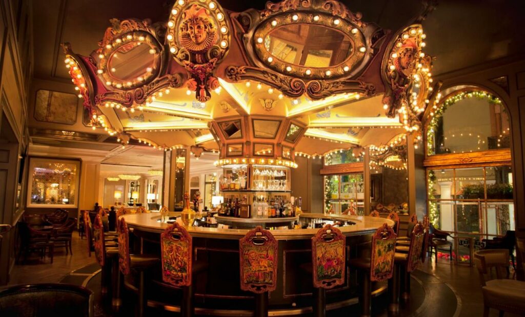 A photo of the bar at Hotel Monteleone which is made from an illuminated repurposed carnival carousel, one of the best boutiqe hotels in New Orleans
