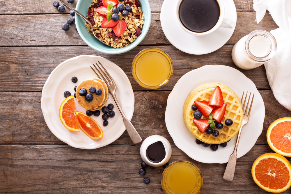 aerial image of fresh fruits, pancakes, waffles and a fruit parfait, the perfect way to start your day!