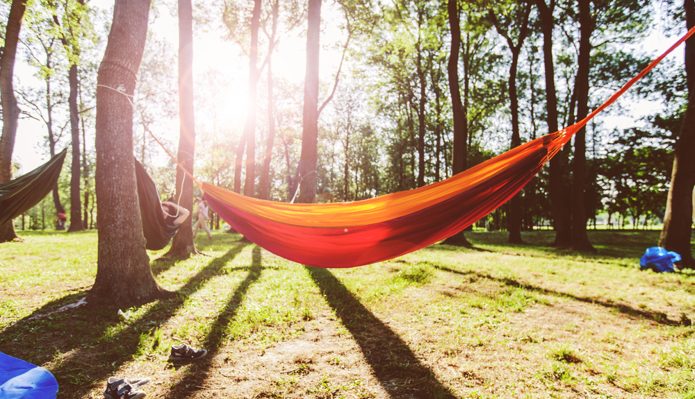 photo of an orange hammock hanging between two trees at one of the best campgrounds in Nashville 