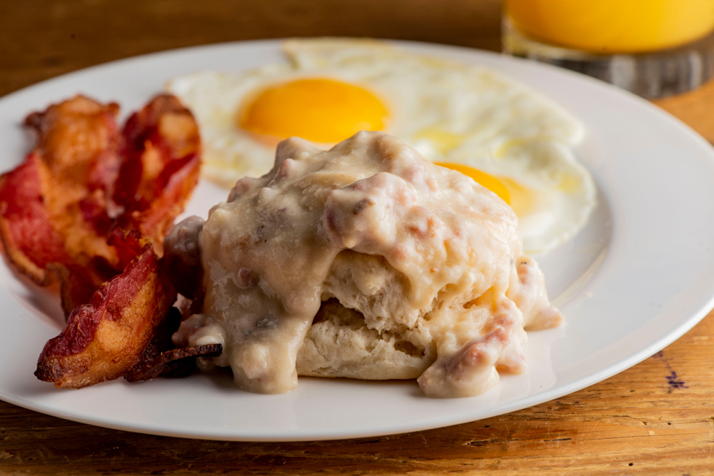 a plate of breakfast food on the table, cimmis courtyard cafe one of the best restaurants in helen GA. plate of bacon, eggs, and biscuits and gravy