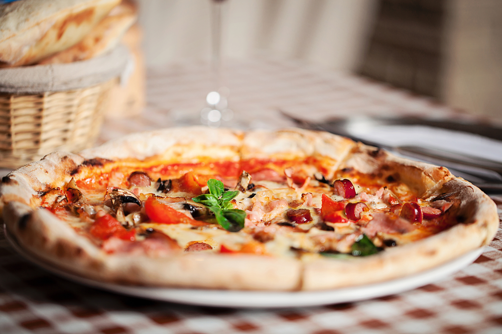 Pizza topped with ingredients on a table in an article about restaurants in Louisville. 