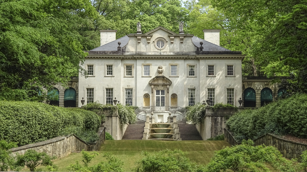 Swan House a huge mansion style home with some steps in front and a green lawn. Going here is one of the best things to do in Atlanta 