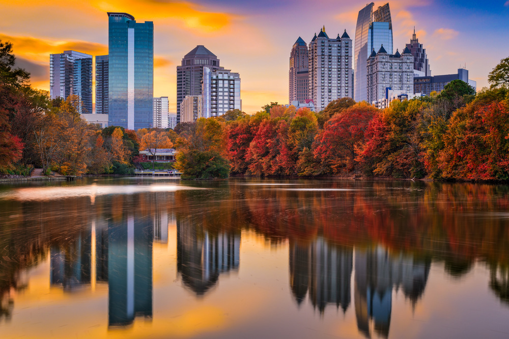 Piedmont Park skyline in autumn showing a lake with trees reflected in it and the skyline in the background. 
